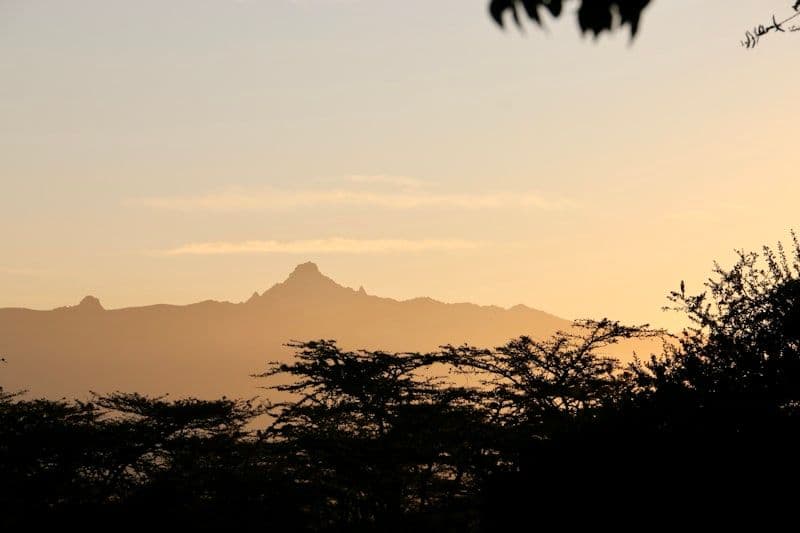 Mountain range bathed in warm sunset light viewed across the Laikipia plateau